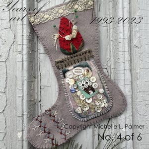 May include: A gray felt stocking with a red felt strawberry, pincushion, and buttons. The stocking has a lace trim and is decorated with white and gray embroidery. The stocking is labeled "Copyright Michelle L. Palmer No. 4 of 6" and "1993 2023".