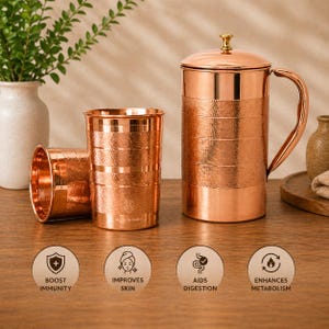 Könnte beinhalten: Ein Kupferwasserkrug mit Deckel, zwei Trinkgläser aus Kupfer und ein drittes Glas, das auf der Seite liegt. Die Kupferartikel haben eine gehämmerten Textur. Der Krug hat einen Griff. Das Bild enthält Symbole mit Text.