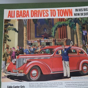 May include: A red 1930s DeSoto car with a man in a blue suit and a hat standing next to it. The car is surrounded by people in front of a building with palm trees. The text "Ali Baba Drives to Town in His Big New DeSoto" is at the top of the image.