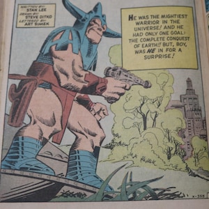 May include: Comic book panel featuring a muscular character in a blue horned helmet and boots, red loincloth, and holding a ray gun. Text bubbles read, "He was the mightiest warrior in the universe!" and "The complete conquest of Earth!!"