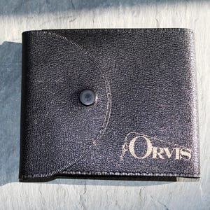 Juego de dos carteras de plástico para líderes ORVIS. Una está vacía. La otra tiene seis líderes cónicos de alta calidad. Probablemente de los años 70 y 80.