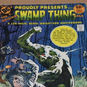 May include: A vintage comic book cover for "Swamp Thing" from 1977, featuring a green monster in a fight scene. The cover includes text that reads "The Original" and "A Len Wein-Berni Wrightson Masterwork."