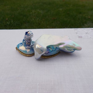 May include: A small, iridescent blue and white porcelain trinket box shaped like a heart with a frog figurine on top.