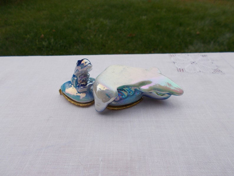 May include: A small, iridescent blue and white porcelain trinket box shaped like a heart with a frog figurine on top.