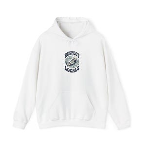 May include: A white hooded sweatshirt featuring a central graphic of a sea otter floating in green kelp. The text "RESPECT LOCALS" is printed in dark blue, arched above and below the otter illustration. The hoodie includes a front kangaroo pocket.