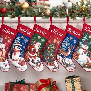 May include: Six Christmas stockings with red cuffs featuring the names Alison, Sophia, Janice, Olivia, Renata, and Elaine. Each stocking displays a unique holiday scene including a polar bear, penguin, Santa Claus, tree, reindeer, and snowman.