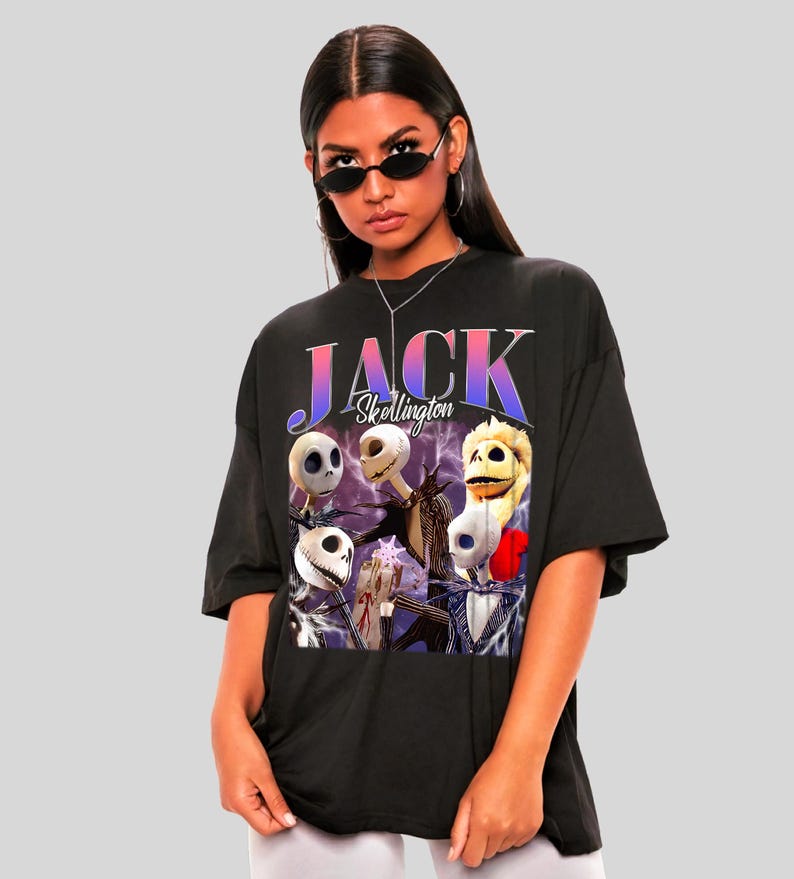 May include: Black oversized t-shirt featuring a graphic of Jack Skellington and other characters from The Nightmare Before Christmas. The word "JACK" is printed in a gradient font above the characters. The shirt is worn by a person wearing sunglasses.