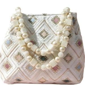 Puede incluir: Bolso acolchado blanco con asa y correa de cuentas de perlas. El bolso presenta un patrón de diamantes geométricos con acentos pastel. El asa está hecha de perlas y cuadrados blancos alternos.