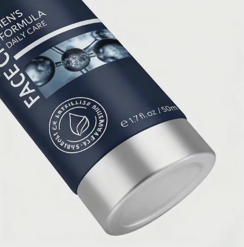 May include: A close-up of a dark blue tube of face cream with silver accents. The tube has white text that reads "MEN'S FORMULA DAILY CARE FACE". The bottom of the tube is silver and contains 1.7 fl. oz / 50ml.