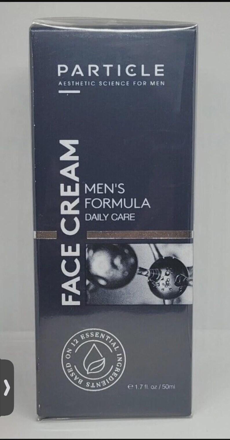 May include: A dark gray box of Particle Face Cream. The box features the brand name "PARTICLE" and the text "Aesthetic Science For Men." It also includes "Men's Formula Daily Care" and "Face Cream." The product contains 1.7 fl oz / 50ml.