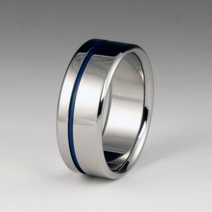 May include: A silver titanium ring with a blue inlay. The ring is polished and has a smooth finish.