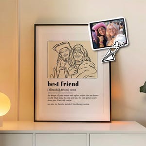 Op de afbeelding: Een ingelijste print met de woorden "beste vriend" en een definitie. De print toont een lijntekening van twee mensen en een kleine foto van twee vrouwen. De definitie bevat zinnen als "lelijkste selfies" en "deel je frietjes".