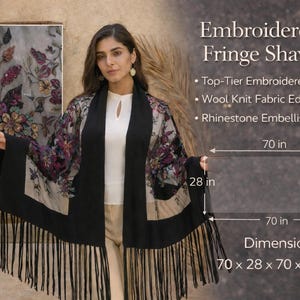 Embroidered fringe shawl with floral embroidery and black fringe. The shawl measures 70 x 28 x 70 x 28 inches. Features top-tier embroidered tulle, wool knit fabric edges, and rhinestone embellishments.