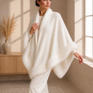 Luxury ivory shawl with faux fur trim styled over an elegant knit outfit, soft bridal inspired wrap for weddings and formal events.