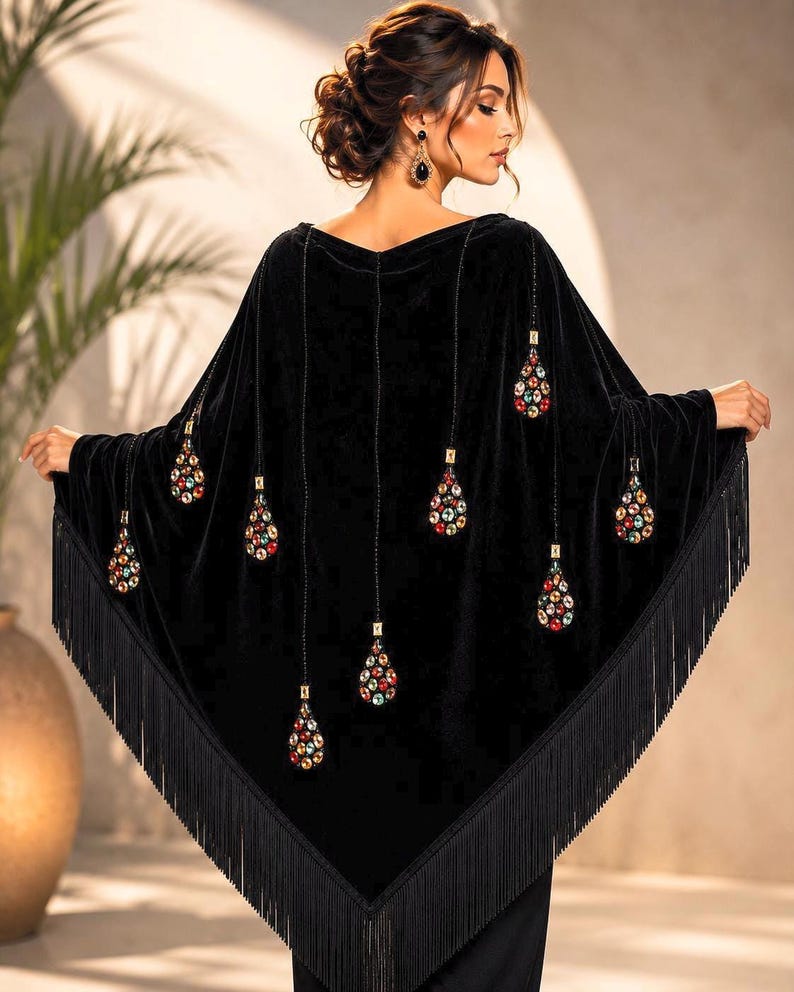 Luxury black velvet shawl with colorful jeweled embellishments and long black fringe, worn by an elegant woman in a professional studio setting, back view showcasing detailed handcrafted design.