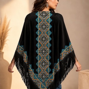 Black shawl with a geometric design in teal, orange, and gold. The poncho has fringe along the bottom and sleeves. The design is centered on the back and along the edges of the sleeves.