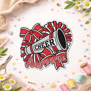 May include: An embroidered patch featuring a red and white megaphone with the word CHEER printed in black block letters. The design includes red bows and a red and white pom-pom background with a space for a custom name in red script lettering.