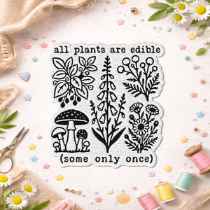 May include: A white embroidered patch with black thread detailing featuring botanical illustrations of mushrooms, flowers, and foliage. The text reads all plants are edible at the top and (some only once) at the bottom in a typewriter font.