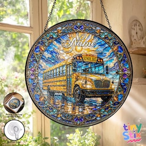 May include: Round stained glass window art featuring a yellow school bus under a bright sun with the word "Name" above it. The design includes a blue sky and decorative border. Includes a suction cup and gift box.