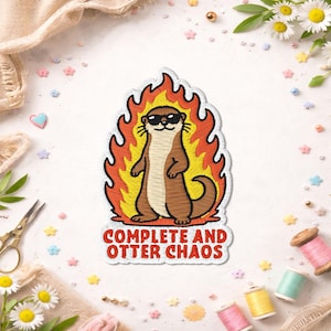May include: Embroidered patch featuring a cool otter wearing sunglasses, surrounded by flames. The patch reads "COMPLETE AND OTTER CHAOS" in red text. The otter is brown and tan, with a yellow and orange flame design.