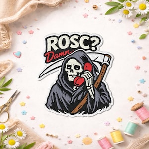 May include: Embroidered patch depicting the Grim Reaper in a black hooded cloak, holding a red telephone and a scythe. The patch has the text "ROSC? Damn..." in white and red. The patch is surrounded by white fabric and colourful embellishments.
