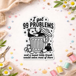 May include: A black and white patch featuring an opossum in a trash can. The text reads "I got 99 problems and a sweet little break would solve most of them." The patch is surrounded by decorative elements.