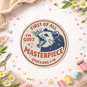 May include: Embroidered patch with a cream background and a red border. The patch features a blue and white opossum design with the text "FIRST OF ALL I'M GOD'S MASTERPIECE EPHESIANS 2:10" in red and white. The patch is round.