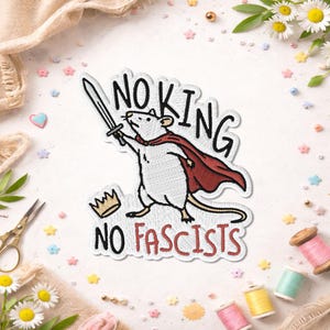 May include: Embroidered patch showing a white rat in a red cape, holding a sword. The patch reads "NO KING NO FASCISTS" in black and red. A gold crown is also part of the design.