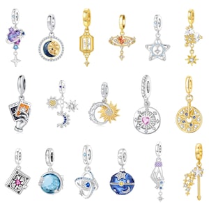 May include: A collection of eighteen celestial-themed charms featuring various designs including planets, stars, moons, suns, tarot cards, and hands, crafted in silver and gold tones with embedded clear, blue, pink, and purple crystals and stones.