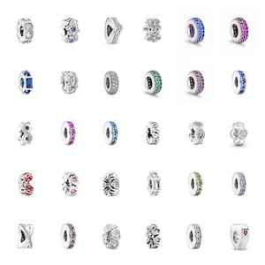 Könnte beinhalten: Eine Sammlung von silberfarbenen Charm-Beads mit verschiedenen Designs. Einige Beads sind mit klaren oder farbigen Edelsteinen verziert, während andere florale, herzförmige oder geometrische Muster aufweisen. Die Beads sind für Armbänder oder Halsketten konzipiert.