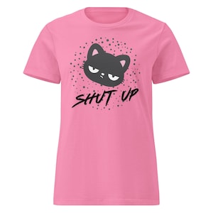 May include: Pink t-shirt with a graphic of a grumpy cat face and the words "SHUT UP" in black. The cat graphic is surrounded by small gray dots.