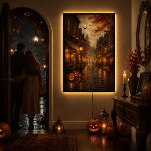 Puede incluir: Una pieza de arte mural rectangular que muestra una escena iluminada de una calle empedrada por la noche con hojas de otoño, luces de cadena y calabazas talladas. La obra está enmarcada con retroiluminación integrada.