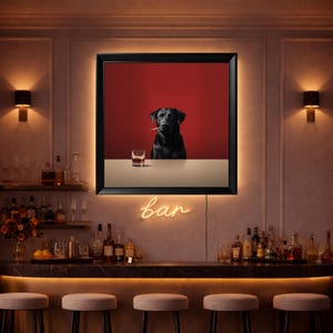 May include: A framed print showing a black Labrador with a cigarette, set against a red background. A glass of amber liquid sits on a table. The word "bar" is written in neon.
