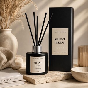 May include: A black reed diffuser with the text "SILENT GLEN" and a matching box. The diffuser has black reeds and a silver collar. The box also has the text "SILENT GLEN" and "100 ML MADE IN SCOTLAND".