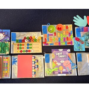 May include: A collection of educational toys and activities for children, including wooden puzzles, colorful blocks, and a "Snip, Snip!" activity set. The image also features hand-shaped cutouts and various other learning tools.