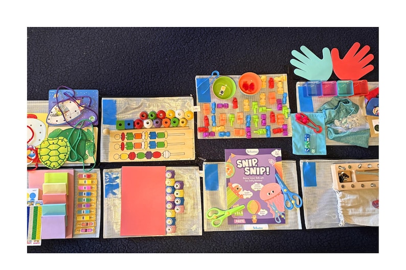 May include: A collection of educational toys and activities for children, including wooden puzzles, colorful blocks, and a "Snip, Snip!" activity set. The image also features hand-shaped cutouts and various other learning tools.