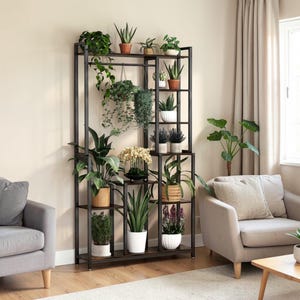 Puede incluir: Un estante para plantas de metal negro con múltiples estantes, que muestra varias plantas en macetas. El estante tiene forma rectangular y está lleno de follaje verde, incluidas plantas colgantes. El estante se coloca en un salón con muebles de tonos neutros.