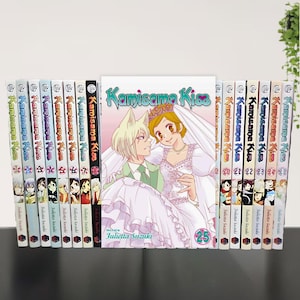 May include: A collection of "Kamisama Kiss" manga volumes. The spines display the series title and volume numbers. The central volume features a couple in wedding attire. The author's name, Julietta Suzuki, is visible.