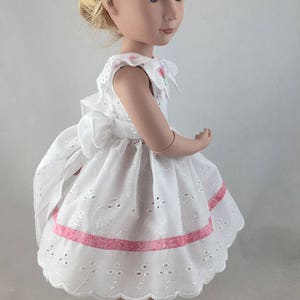 May include: A white eyelet dress with pink ribbon trim and a scalloped hem. The dress is worn by a doll with blonde hair and blue eyes. The doll is wearing pink shoes. The image includes the text "Special Patterns Crabapples for Special Dolls".