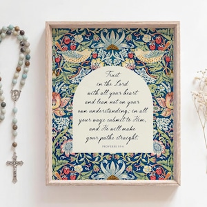 Puede incluir: Impresión enmarcada con un diseño floral y de pájaros, con el texto "Trust in the Lord". También hay un rosario y flores secas. El marco es de color claro y el fondo es blanco.