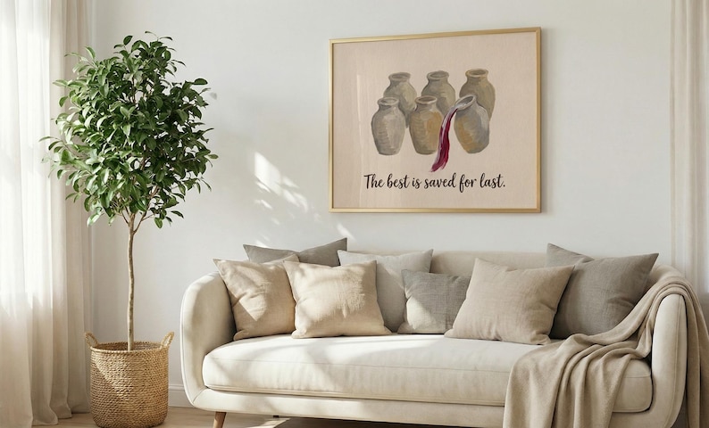 May include: A framed wall art print featuring a group of six beige ceramic jars, with one jar pouring out dark red liquid. Below the jars, the text reads, The best is saved for last. The artwork is displayed in a thin gold frame on a white wall.
