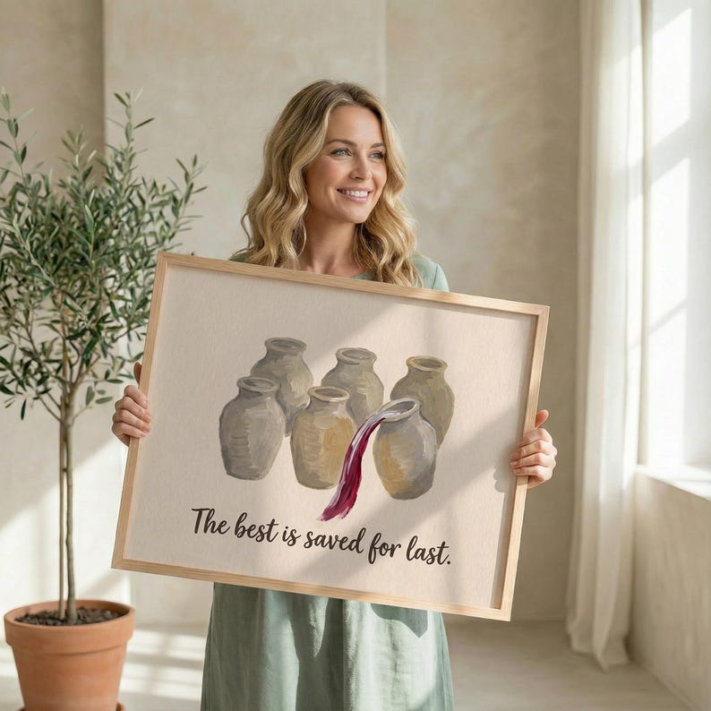 May include: A rectangular framed print featuring a beige background with an illustration of five tan ceramic jars. One jar is tilted, pouring dark red liquid into another. The text "The best is saved for last." is printed in black below the jars.