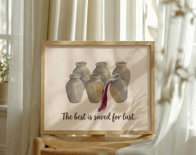 May include: A framed print featuring six light brown ceramic jars arranged in a group. One jar on the right is tilted, pouring out a stream of dark red liquid. Below the jars, the text reads, "The best is saved for last." in a dark font.