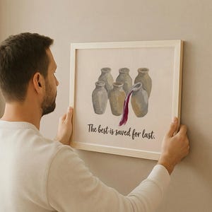 May include: A framed wall art print featuring a light-colored background with an illustration of six beige ceramic jars. One jar is pouring out a stream of dark red liquid. Below the jars, the text reads, The best is saved for last.