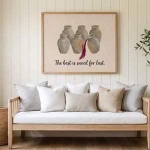 May include: A rectangular wall art print in a light wood frame featuring a beige background with six gray ceramic jars. One jar is pouring dark red liquid. The text "The best is saved for last." is printed in black below the jars.