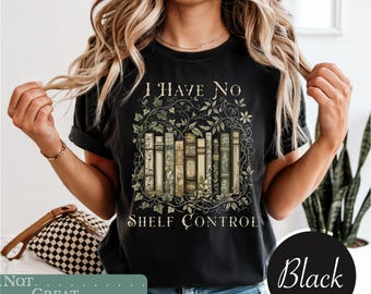 May include: A black short-sleeve t-shirt featuring a graphic of a row of books intertwined with green vines and leaves. The text "I HAVE NO" is printed above the books, and "SHELF CONTROL" is printed below in a decorative serif font.