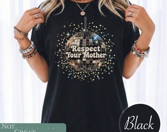 May include: A black t-shirt featuring a graphic of a silver disco ball with the text Respect Your Mother printed in the center. The design is surrounded by small gold and silver star and confetti shapes, creating a festive and reflective appearance.