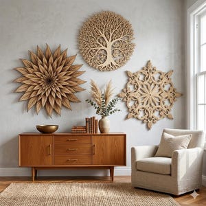 May include: Wooden wall art decor featuring a large flower, a tree, and a snowflake design. The art is mounted on a light gray wall above a mid-century modern style wooden cabinet. A beige armchair and a woven rug complete the room.