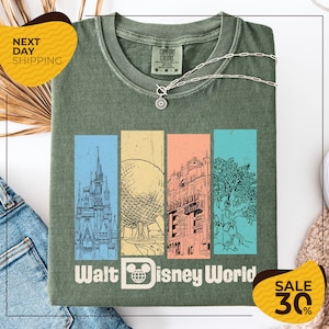 a green t-shirt with a graphic design of Disney World landmarks, including a castle, roller coaster, and other iconic structures. The t-shirt is displayed on a white background, and there are two yellow sale tags visible, one on the left and one on the right, indicating a 30% discount on the item.