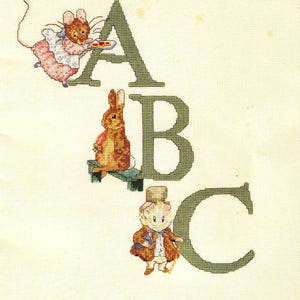 May include: A cross-stitch embroidery on cream fabric featuring the letters A, B, and C in dark green. The letter A is paired with a mouse in a pink dress, B with a brown rabbit eating a carrot, and C with a mouse wearing a brown coat and hat.